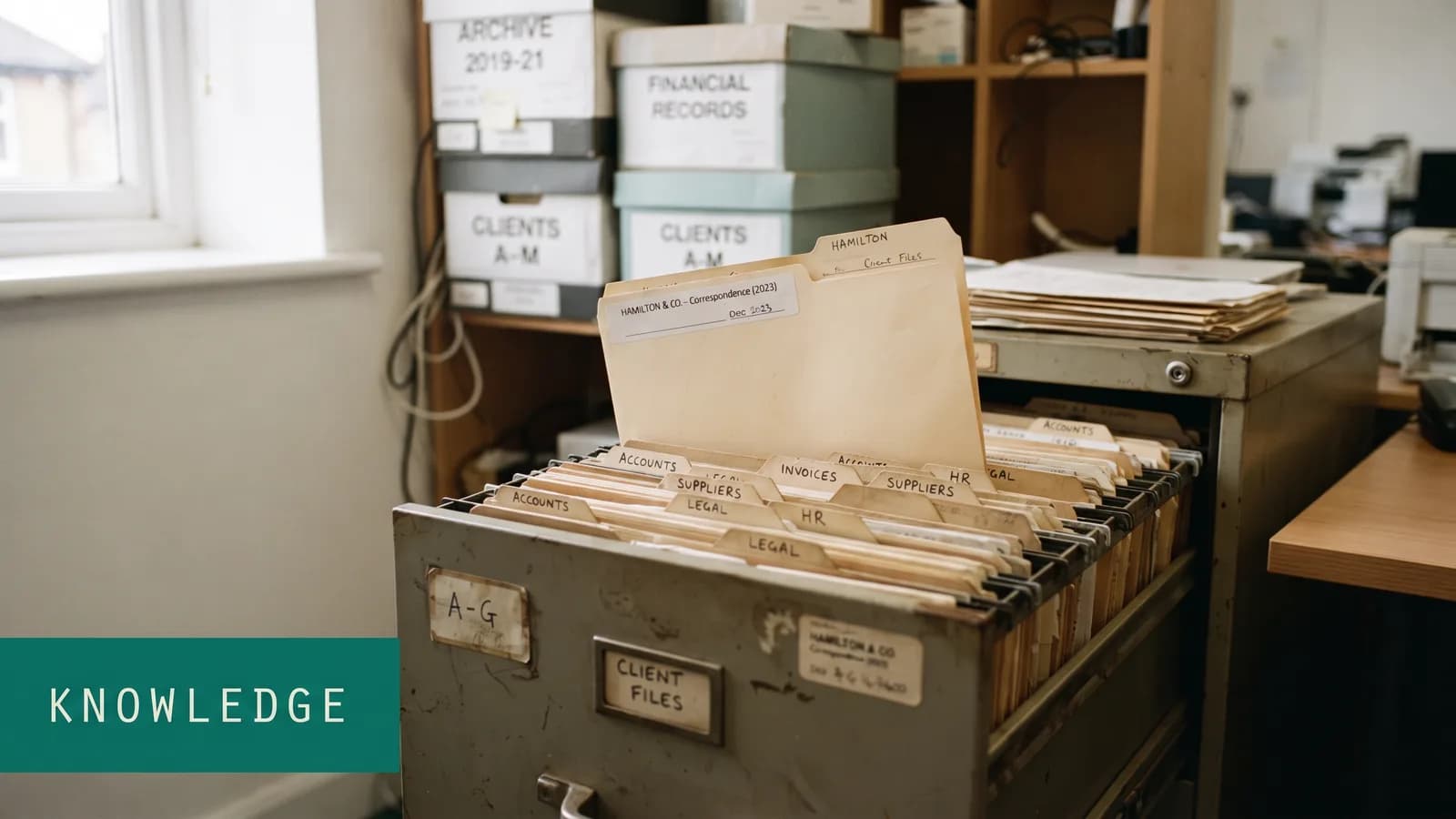 An open filing cabinet drawer of tabbed folders with one lifted proud of the rest